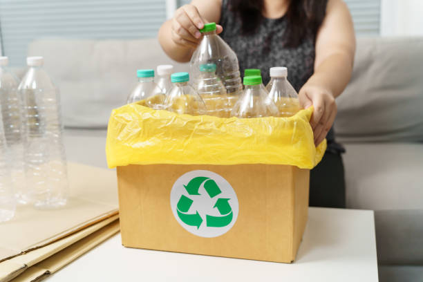 istock Home recycle eco green zero concept Woman throwing empty plastic bottle in recycling bin with yellow garbage bags at home. 2181102969