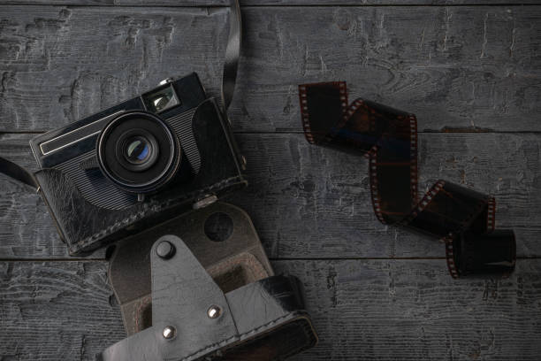 istock Vintage Camera with Film Roll on Rustic Wooden Background 2181105604