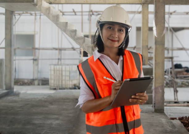 istock Engineer civil woman wearing uniform safety and hardhat holding digital tablet using stylus pen writing on tablet, working inspector new project building at construction sites 2181107354