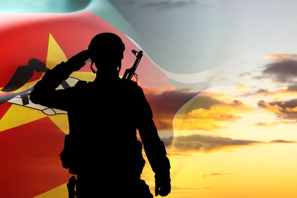 Silhouette of a soldier with Mozambique flag against the sunset. National Holidays concept