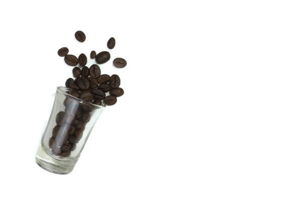 Roasted coffee beans in a glass isolated on a white background