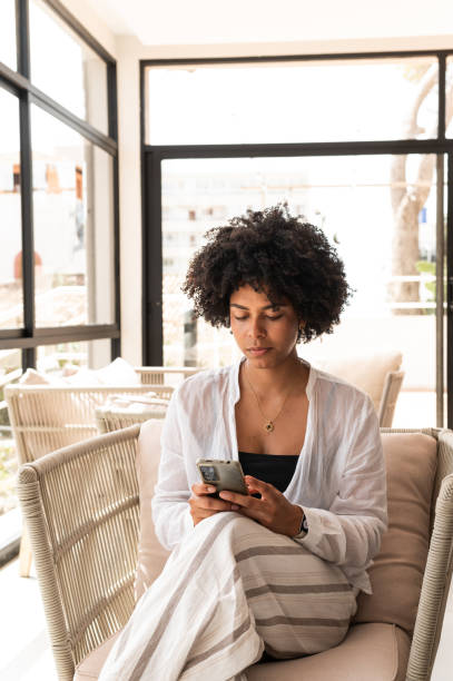 istock African businesswoman using mobile phone sitting on luxury lobby 2181122337