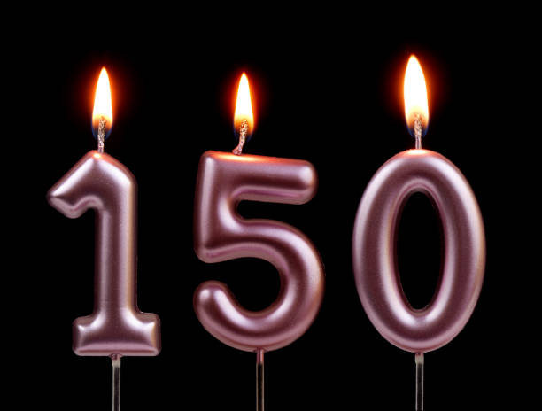 istock Pink birthday candles isolated on black background, number 150 2181122712
