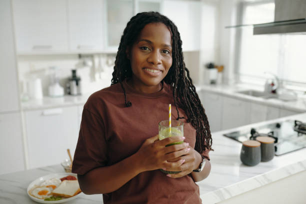 istock Portrait of Smiling Woman Holding Glass in Modern Kitchen 2181126708