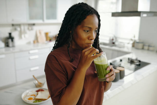 istock Enjoying Healthy Green Smoothie in Modern Kitchen 2181126775