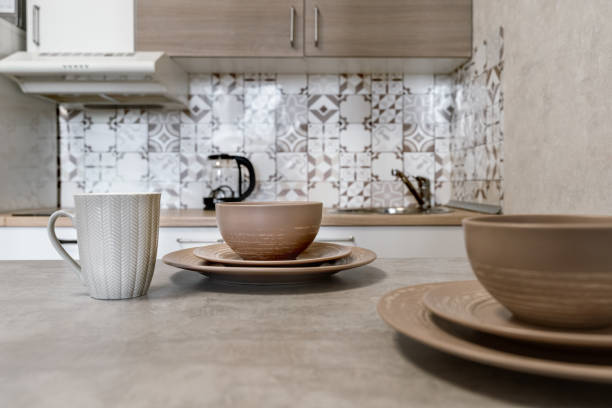 istock design of modern beige kitchen. brown dishes on kitchen table. Plates of different sizes and ceramic mugs. Setting table for breakfast, lunch or dinner. cozy evening at home. Breakfast for two. 2181127010