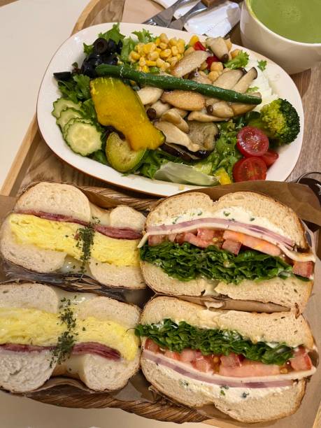 istock Delicious Bagels sandwiches with cheese, ham, cherry tomatoes and salad for breakfast. Copy space 2181127162