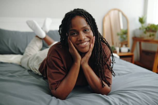 istock Smiling Woman Relaxing on Bed with Hands on Face 2181127379
