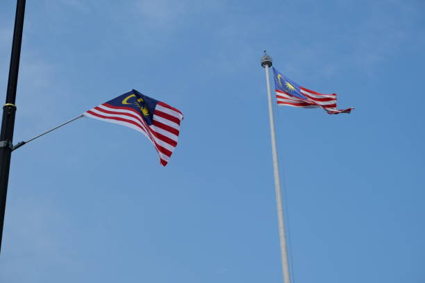 istock Some Malaysian flag waving from its poles with blue sky background 2181132047