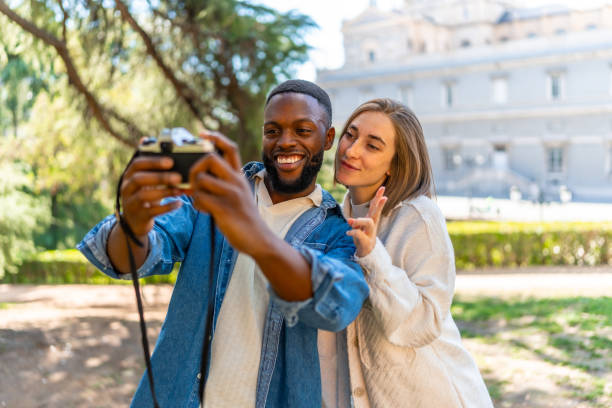 istock Cute multi-ethnic couple taking selfie with digital camera 2181133712