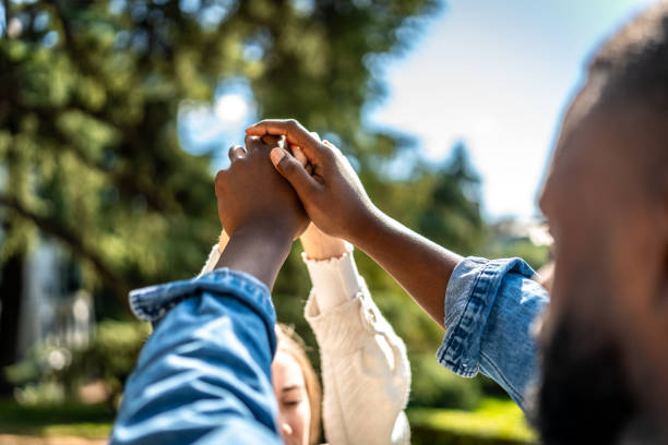 istock Multi-ethnic couple holding hands in a park 2181133768