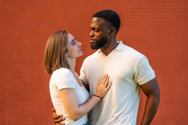 istock Mixed raced couple standing embracing and looking at each other 2181133833