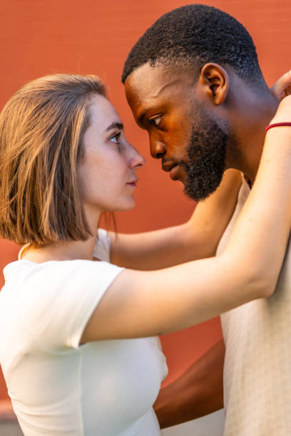 istock Multi-ethnic couple in love touching faces looking at each other 2181133868