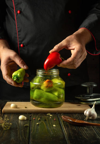 istock The concept of preserving bell peppers for long-term storage using a unique recipe. Chef holding red pepper in his hand in the kitchen 2181134119