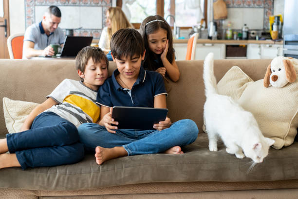 istock Three siblings watching a movie on a portable device 2181134918