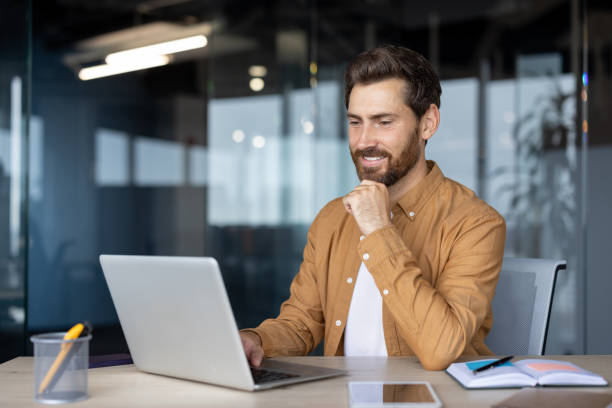 istock Confident businessman in modern office working on laptop with focus and dedication 2181138141