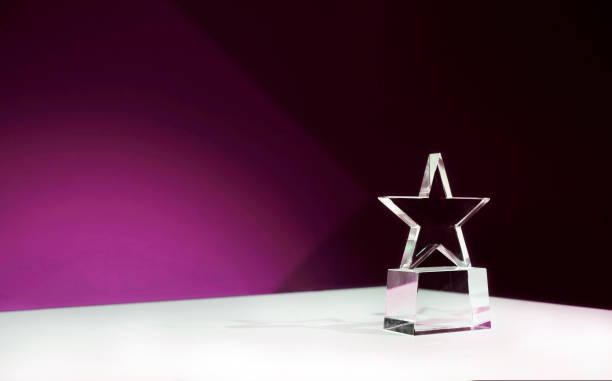 istock Star-shaped award on a table with purple spotlights and copy space 2181142021