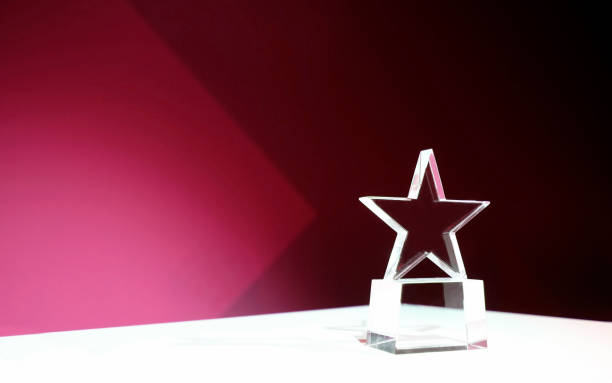 istock Star-shaped award on a table with pink spotlights and copy space 2181142028