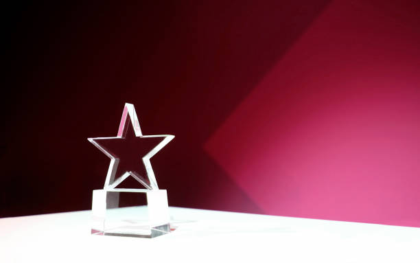 istock Star-shaped award on a table with pink spotlights and copy space 2181142034