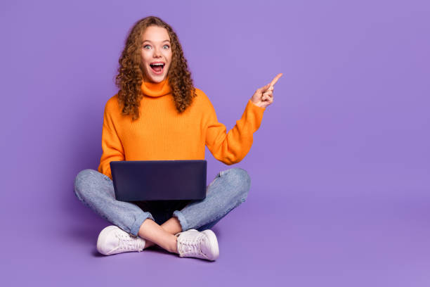 istock Full size photo of nice young girl netbook indicate finger empty space wear pullover isolated on violet color background 2181143949