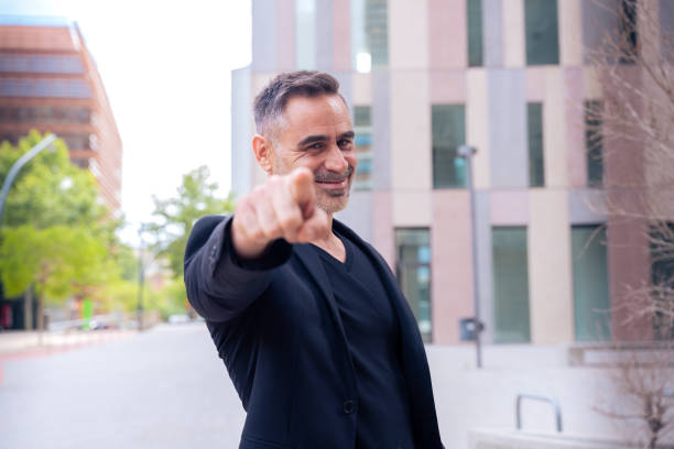istock Confident and smiling business man pointing forward looking at camera outdoors 2181144257