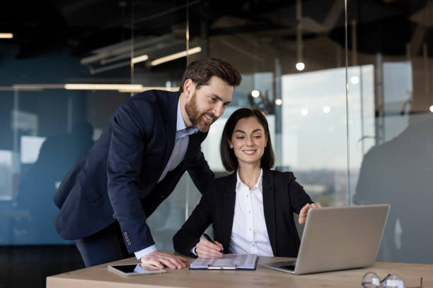 istock Business colleagues collaborating on project with laptop in modern office environment 2181148228