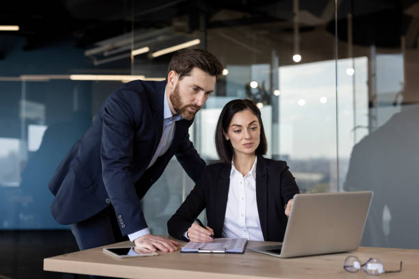 istock Business professionals discussing project using laptop in modern office setting, collaborating effectively to achieve goals 2181148447