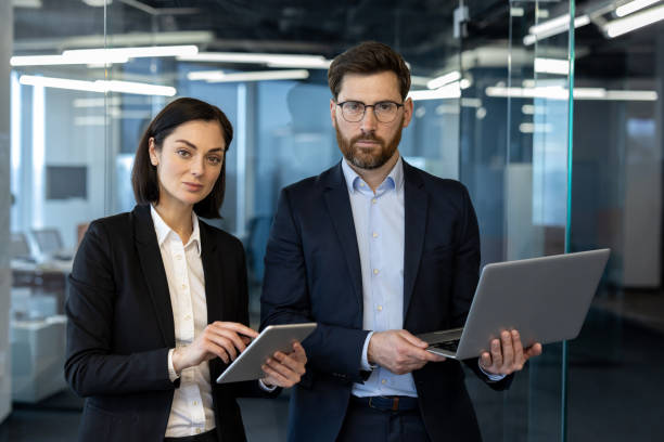 istock Confident business professionals collaborating with digital devices in modern office setting 2181150270