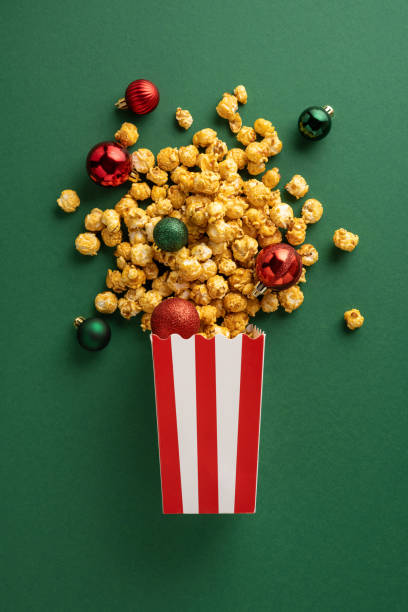 istock A vertical vibrant display of popcorn spilling from a striped box, surrounded by colorful Christmas ornaments on a green background. Perfect for festive and holiday-themed designs 2181152709