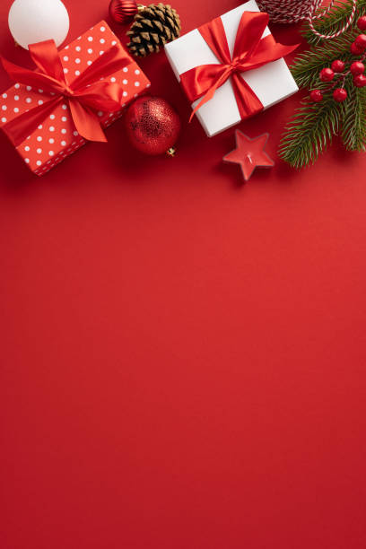 istock A vibrant vertical red background with Christmas gifts, pine cones, and ornaments creates a festive holiday atmosphere. Ideal for celebrating Merry Christmas and Happy New Year 2181152721