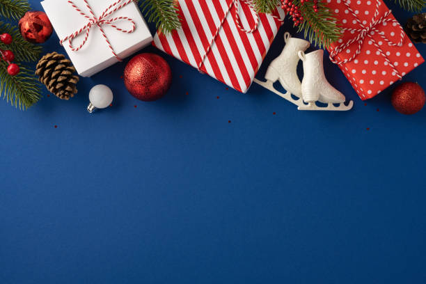 istock Holiday-themed image featuring wrapped gifts, pine branches, and festive decorations arranged creatively on a vibrant blue surface 2181152723
