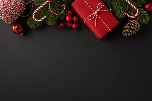 istock A top-down view of festive Christmas decorations featuring a wrapped gift, pine branches, red ornaments, and candy canes on a dark background creating a cheerful holiday atmosphere 2181152770