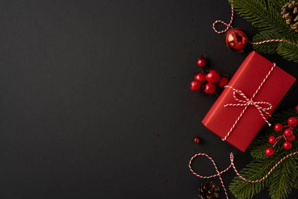istock Red Christmas present surrounded by festive decorations and ornaments on a dark background creating a cozy holiday atmosphere 2181152774