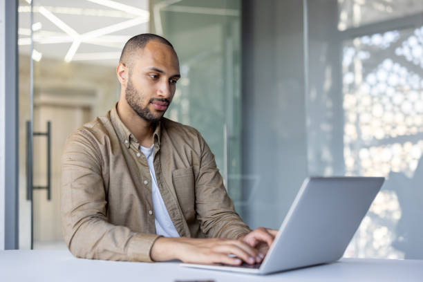 istock Focused professional man working on laptop in modern office environment, demonstrating dedication and concentration during business tasks 2181154024