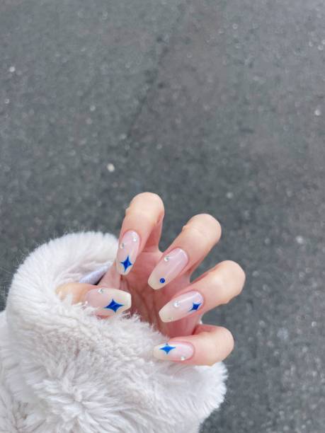 female hands with beautiful long nails with manicure with cute pattern