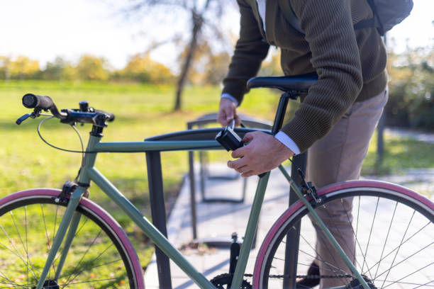 Close-up of a man's hands locking his bicycle in the park, on a bicycle rack