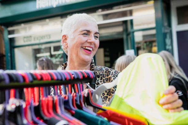 istock Cheerful woman browsing for clothes on a market stall 2181160857