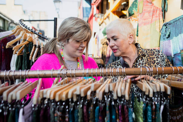 istock Two friends browsing clothes on a market stall 2181160920