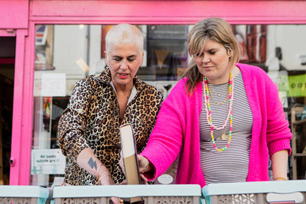 istock Two friends browsing used books outside a shop 2181161412