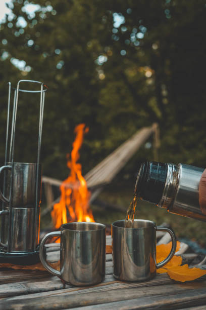 istock Themed trip. The man pours a hot drink into the thermos 2181175092