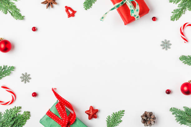 istock Christmas frame made of fir branches, gift boxes, red decorations, candy and pine cones on white background. Flat lay. Happy New Year and winter holidays background. Top view 2181188863