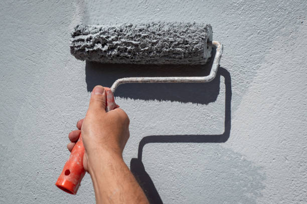 istock Painter with roller in hand painting the wall 2181190558