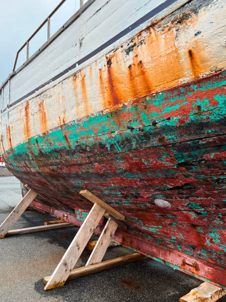 Closeup partial view of a large old wooden fishing boat on display in the harbor on the North Atlantic Ocean. Located in Nólsoy, Faroe Islands with a long history of fishing. Remote Scandinavian archipelago of Islands.