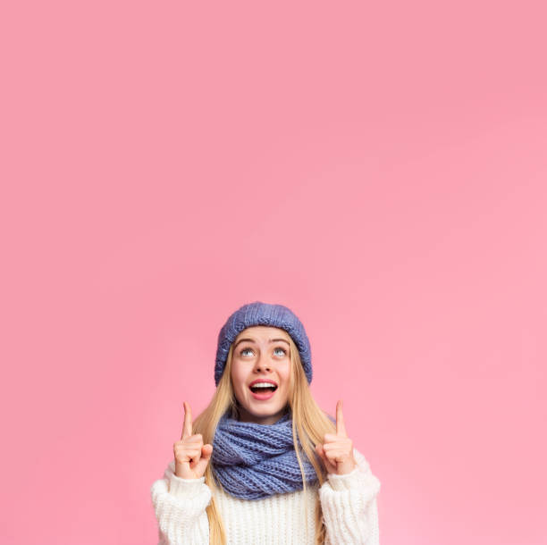 istock Amazed girl in blue hat pointing up at copy space 2181192251