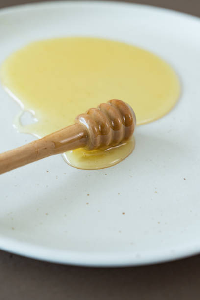 Fresh honey on plate with honey dipper