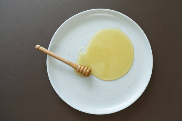 Fresh honey on plate with honey dipper