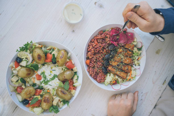 Overhead view of young man eating vegan meal at outdoor cafe