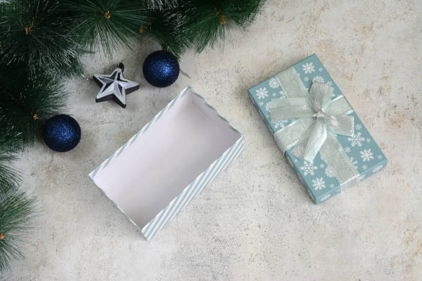 istock an open gift box with in front of a christmas tree branches and ornaments 2181193828