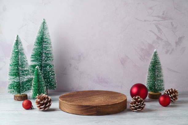istock Empty log podium and and pine tree decoration on white wooden table over bright wall  background. Christmas mock up for design and product display. 2181194239
