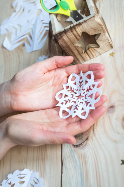 istock A snowflake made from paper with your own hands gracefully decorates a winter interior, adding warmth and a cozy atmosphere 2181199282